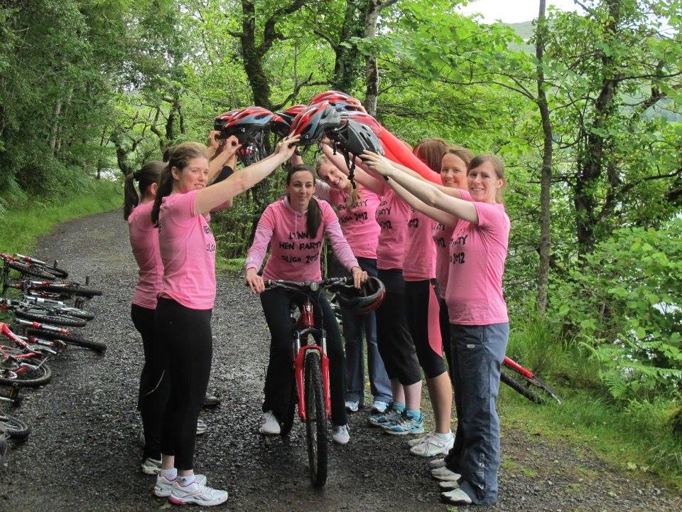 tourists forming an arch with their hands with a woman cycling through the centre