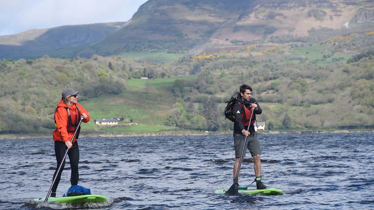 two people doing stand up paddle on the river bonnet