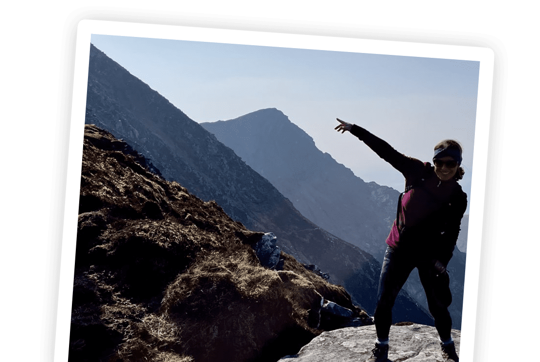 woman with hand pointing toward mountain peak in polaroid image doing hiking adventure